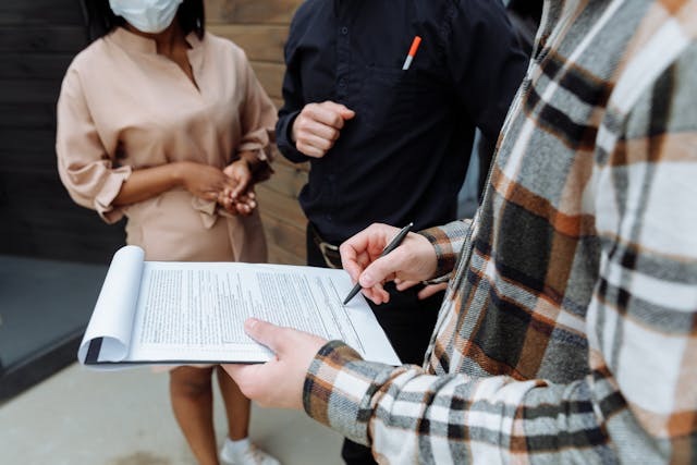 three people reading through a lease agreement