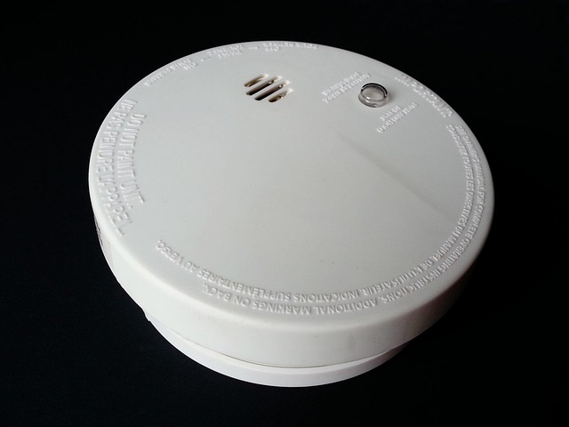 White smoke detector on a dark background
