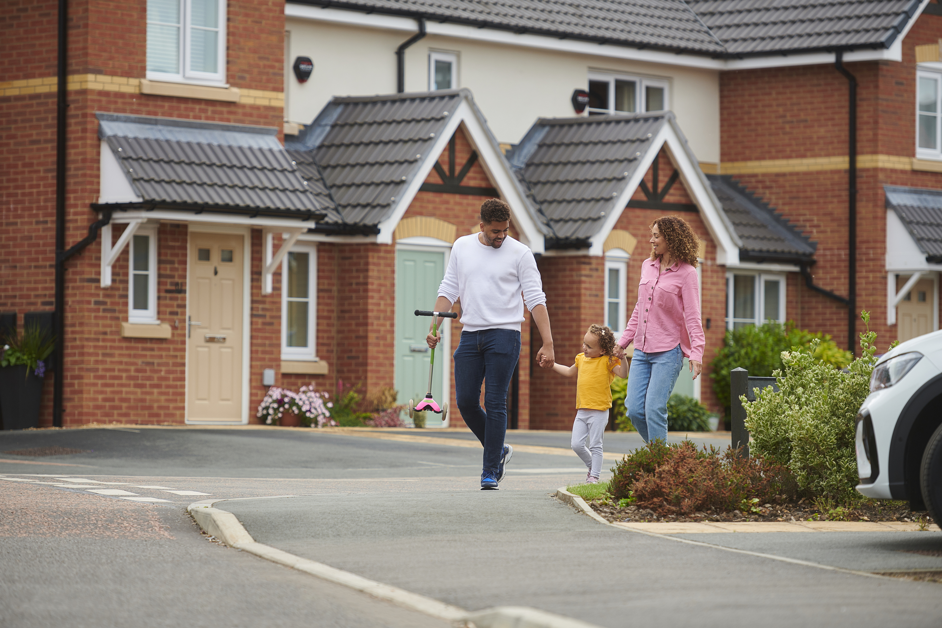 Three people walking while all holding hands