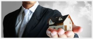 Image of a man holding a tiny house in the palm of his hand