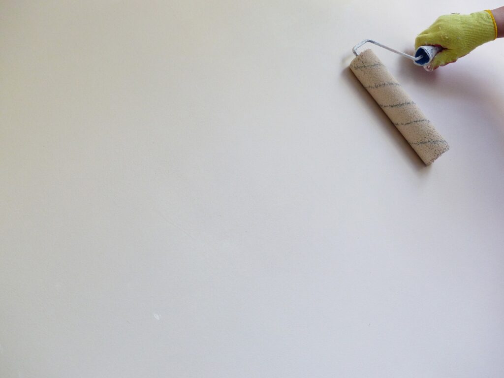 A person painting a wall, one of the landlord-friendly home improvements.